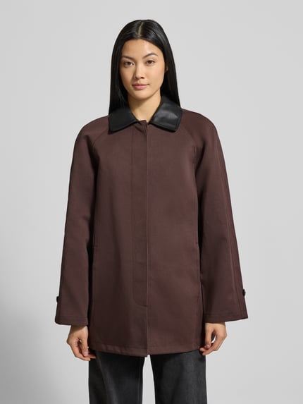 Kobiece model nosi Trenchcoat mit Umlegekragen und verdeckter Knopfleiste od Staud, bawełniany mix, brąz, Relaxed Fit, widok z przodu, ujęcie całej sylwetki.