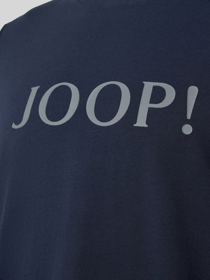 Männermodel trägt Longsleeve mit Logo und Rundhalsausschnitt von JOOP! Collection, dunkelblauer Baumwoll-Elasthan-Mix, Relaxed-Fit, Nahaufnahme Oberkörper