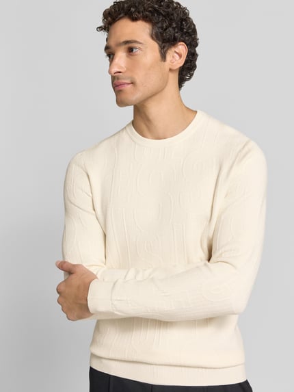 Männermodel trägt Strickpullover aus Viskose-Mix Modell 'NESTOR' von GUESS, cremefarben, Allover-Look, Ganzkörperansicht von vorne. Herren Strickpullover, Slim Fit, Stretch-Anteil, Rundhalsausschnitt, Rückenlänge 66 cm, Ärmellänge 49 cm.