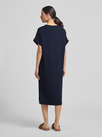 Frauenmodel trägt T-Shirt-Kleid mit V-Ausschnitt von Soyaconcept in Dunkelblau, gerader Schnitt, glatte Textur, Ganzkörperansicht Rückansicht.
