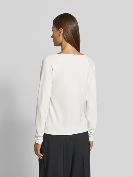 Vrouwenmodel draagt Regular Fit Longsleeve uit viscosemix van monari, elastische mix van viscose en modal, ronde hals, ruglengte maat 36 56 cm, dames shirt met lange mouwen, effen wit design, volledige lichaamsweergave achteraan.