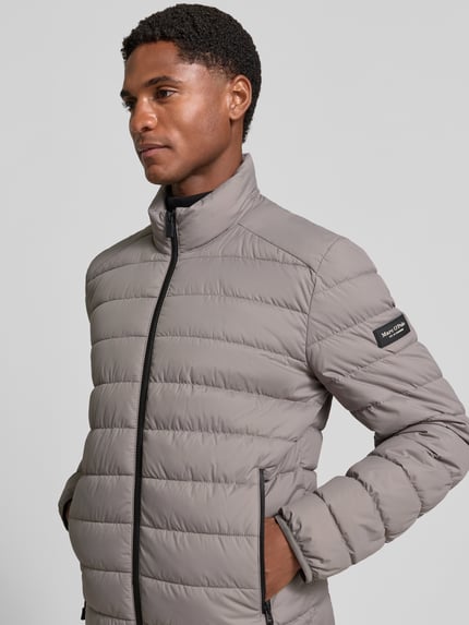 Männermodel trägt Regular Fit Steppjacke mit Zweiwege-Reißverschluss von Marc O'Polo in Grau, sichtbare Steppnähte, Nahaufnahme Oberkörper.