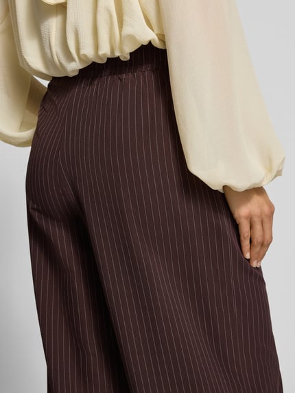 Vrouwenmodel draagt Regular Fit Hose mit elastischem Bund van YAS in matte look met krijtstreep, elastische tailleband detailopname.