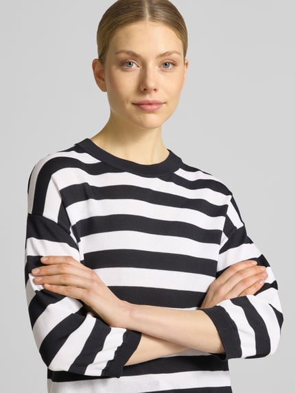 Kobieta nosi Regular Fit Oberteil aus Viskose-Mix Modell 'Lani' od GUIDO MARIA KRETSCHMER WOMAN, czarne i białe pasy, imitacja dzianiny, rękaw o dł. 3/4, okrągły dekolt, elastyczne zakończenia rękawów, długość tyłu 58 cm, długość rękawów 34 cm, mieszanka wiskozy, góra, widok z przodu, zbliżenie na górną część ciała.