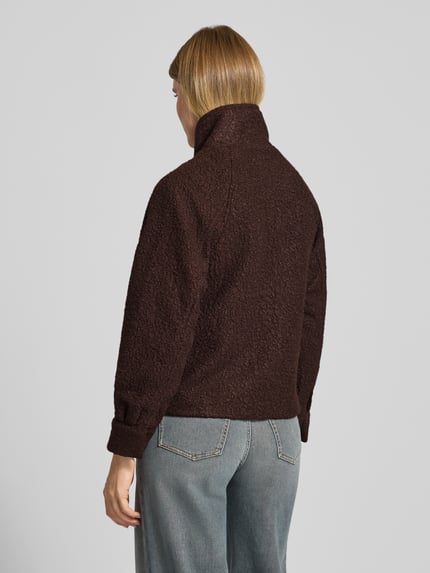 Frauenmodel trägt Kurzmantel mit Stehkragen Modell 'SC-GISA 1' von SOYACONCEPT, braune Bouclé-Struktur, unifarben, Ganzkörperansicht Rückansicht.