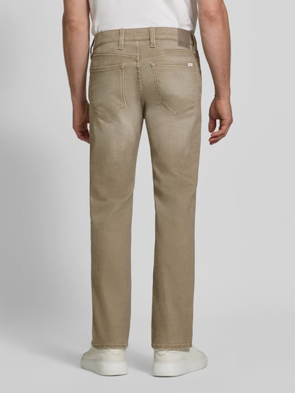Männermodel trägt sandfarbene Relaxed Fit Jeans aus Baumwoll-Mix Modell 'Clint' von Brax, Herren Wide & Loose Fit Jeans, Ganzkörperansicht Rückansicht.