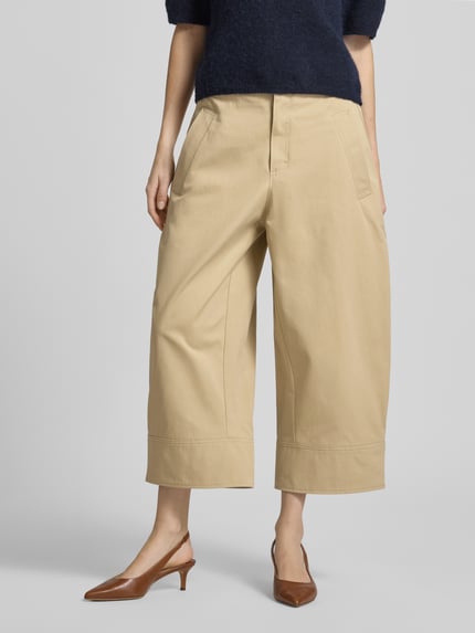 Frauenmodel trägt Loose Fit Chino aus reiner Baumwolle Modell 'Tikkara' von BOSS, Optik: Unifarben, Twill, High-Waist, seitliche Eingrifftaschen, Beinabschluss: Weitenregulierung mit Riegel, Ganzkörperansicht von vorne.