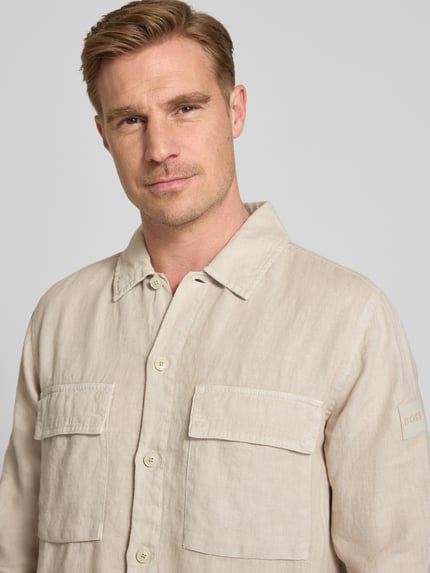 Männermodel trägt Relaxed Fit Freizeithemd aus reinem Leinen Modell 'LOCKY' von BOSS Orange in Optik: Unifarben, Nahaufnahme Oberkörper.