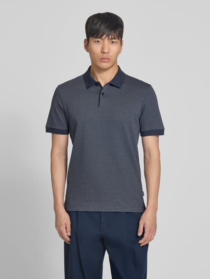 Männermodel trägt Regular Fit Poloshirt aus reiner Baumwolle Modell 'H-PARLAY 102' von BOSS, Bi-Color Optik, Ganzkörperansicht von vorne.