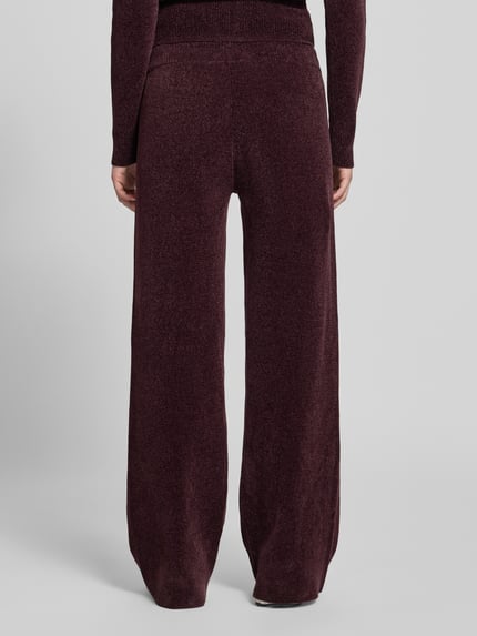 Frauenmodel trägt Sweathose mit Tunnelzug von Juicy Couture in dunklem Unifarben-Look mit Kordeln und elastischem Bund, Ganzkörperansicht Rückansicht.