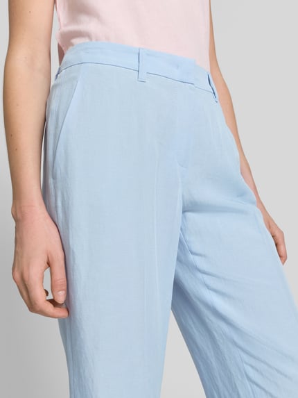 Frauenmodel trägt hellblaue Stoffhose mit Bügelfalten Modell 'OLESSA' von Raffaello Rossi, Viskose-Mix mit Leinen-Anteil, Haken-Reißverschluss, französische Eingrifftaschen, 7/8-Länge, Nahaufnahme Oberkörper