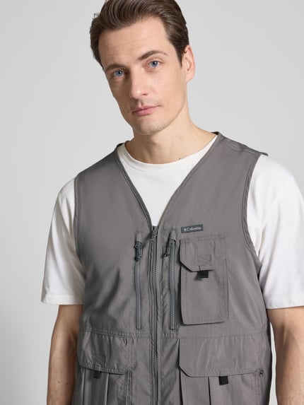 Männermodel trägt grijze Bodywarmer met V-hals, klepzakken en ritssluiting, Model 'SILVER RIDGE' van Columbia, regular fit, Nahaufnahme Oberkörper. Ruglengte maat M: 65 cm, schouderbreedte: 37 cm, borstwijdte: 54 cm.