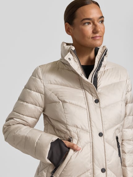 Modelka kobieca nosi Regular Fit Steppjacke mit abnehmbarer Kapuze von Gil Bret, kremowa kurtka, teksturowana powierzchnia pikowana, zbliżenie na górę ciała