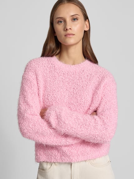 Frauenmodel trägt Strickpullover mit Rundhalsausschnitt Modell 'SASSY' von NOISY MAY®, rosa Effektgarn, strukturierte Oberfläche, Nahaufnahme Oberkörper.