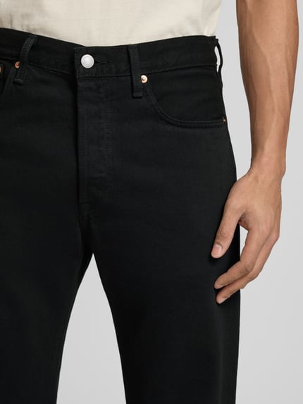 Mannenmodel draagt zwarte heren jeans model '501®' van Levi's®, puur katoen, wide leg fit, knoopsluiting, 5-pocketmodel, labelpatch in band, detailopname heup.