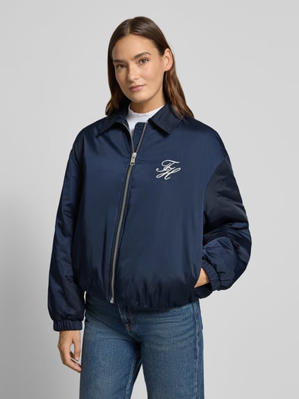 Kobiece model nosi Regular Fit Bomberjacke mit Logo-Detail od Tommy Hilfiger, granatowa, jednolita, z długimi rękawami, widok przód – zbliżenie na górną część ciała.