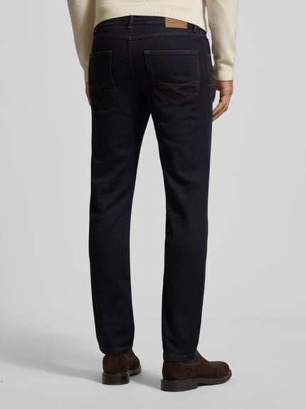 Męski model nosi Slim Fit Jeans mit 5-Pocket-Design od Christian Berg Men, ciemnoniebieski, prosty krój, widok całej sylwetki od tyłu, bawełna bio z domieszką stretchu.