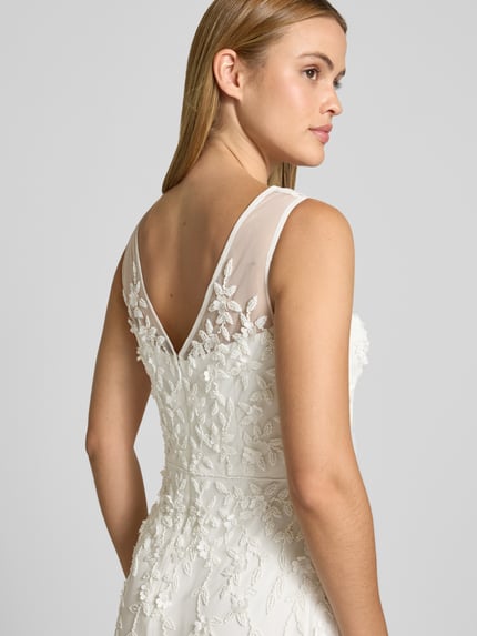 Frauenmodel trägt Maxikleid mit Perlen und V-Ausschnitt von Adrianna Papell aus Mesh im Allover-Look in Weiß, Nahaufnahme Oberkörper. Rückenlänge bei Größe 36: 132 cm, Brustweite bei Größe 36: 37 cm, A-Linie.
