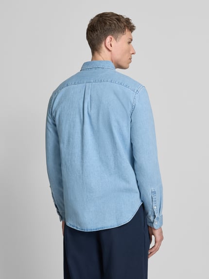 Männermodel trägt Regular Fit Jeanshemd mit Button-Down-Kragen von GAP in hellblauem Baumwoll-Mix mit Stretch-Anteil, Rückansicht.