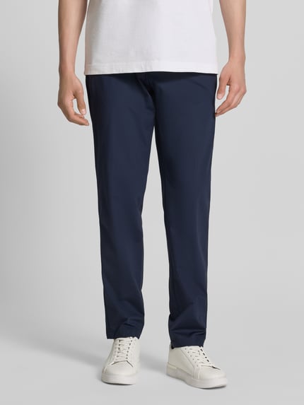 Męski model nosi Slim Fit Anzughose mit Tunnelzug Modell 'GENIUS' von BOSS, jednokolorowy granatowy, krój slim fit, four-way-stretch, elastyczny pas, wpuszczane kieszenie, model z przodu, Ganzkörperansicht von vorne.