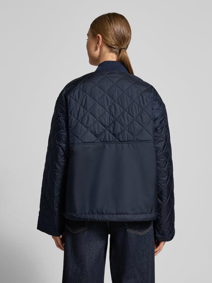 Frauenmodel trägt Relaxed Fit Steppjacke mit Rumpftunnelzug von Barbour, Optik: unifarben, Muster: kariert, Ganzkörperansicht Rückansicht.