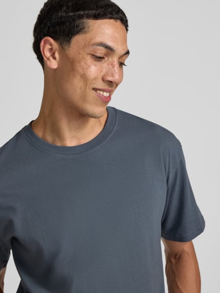 Männermodel trägt Regular Fit T-Shirt mit Rundhalsausschnitt von Jack & Jones in Blau, Reine Baumwolle, 1/2-Arm, Nahaufnahme Oberkörper. Rückenlänge bei Größe M: 70 cm.