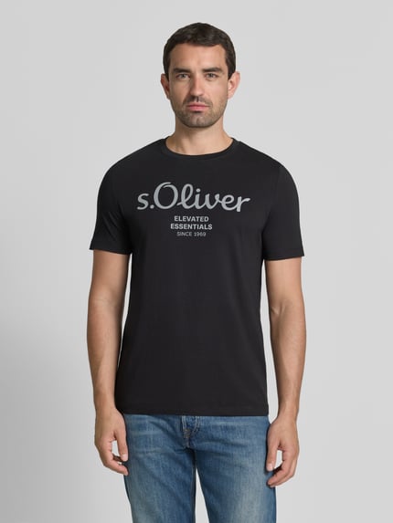 Męski model nosi Regular Fit T-Shirt aus reiner Baumwolle Modell 'BASIC TEE BIG LOGO' von s.Oliver RED LABEL, czarny, gładka faktura, widok z przodu, całe ciało.
