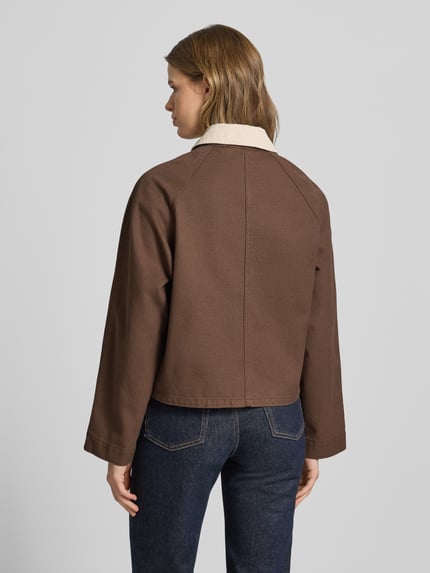 Frauenmodel trägt Regular Fit Jeansjacke aus reiner Baumwolle Modell 'BETT' von Pieces in Braun mit Umlegekragen und Cord-Besatz, Optik: Unifarben, Denim-Materialverarbeitung, Ganzkörperansicht Rückansicht.