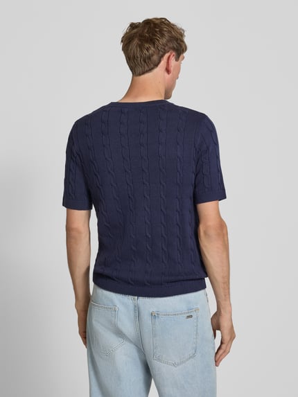 Männermodel trägt Slim Fit T-Shirt in Strick-Optik von REVIEW, reine Baumwolle, dunkelblau, Logo-Stitching, Rückenlänge 59 cm, Ganzkörperansicht Rückansicht.