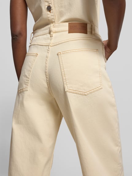 Vrouwenmodel draagt Straight Fit Jeans met siernaden van BAUM & PFERDGARTEN in lichtgeel katoenmix, 5-pocketmodel, knoop- en ritssluiting. Ganzlichaamsaanzicht achteraan.