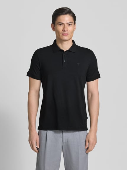 Męski model nosi Regular Fit Poloshirt mit Knopfleiste Modell 'Carlosjuan' od JOOP! Collection, czarny, mieszanka bawełny ze stretchem, krój regular fit, kołnierzyk polo, krótka listwa guzikowa, długość pleców w rozmiarze M: 69 cm, pełny widok z przodu.