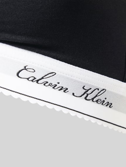 Produktfoto, czarny biustonosz typu bralette model 'SCRIPT Lightly Lined' z mieszanki bawełny i modalu od Calvin Klein Underwear, kontrastowe, białe wykończenie z napisem, gładka tekstura