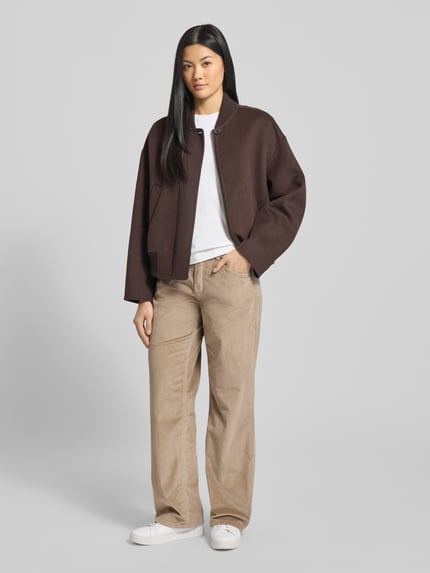 Vrouwenmodel draagt Wide Fit Cordhose mit Eingrifftaschen Modell 'Liv' van TONI in beige, structuur van ribfluweel, volledige vooraanzicht. Elastische katoenmix, steekzakken, knoop- en ritssluiting, taillewijdte 40 cm, binnenbeenlengte 19 cm bij maat 36.