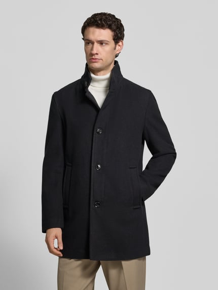 Männermodel trägt Daunenjacke Modell 'Fynn' mit Stehkragen von Strellson, unifarben matt, strukturierte Optik, seitliche Eingrifftaschen, Ganzkörperansicht von vorne.