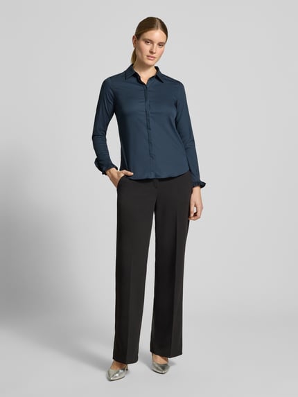 Frauenmodel trägt Hemdbluse aus Baumwoll-Mix Modell 'Mattie' von MOS MOSH in Dunkelblau mit Knopfleiste und Rüschen, Ganzkörperansicht von vorne. Elastischer Stoff, Slim Fit, langer Ärmel, Hemdblusenkragen, abgerundeter Saum.