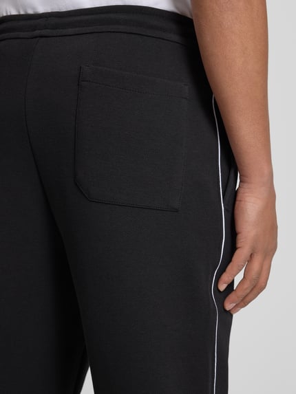 Männermodel trägt Regular Fit Sweatpants aus Baumwoll-Mix Modell 'JOIN HADIKO' von BOSS Green mit Piqué Material, Detailaufnahme.