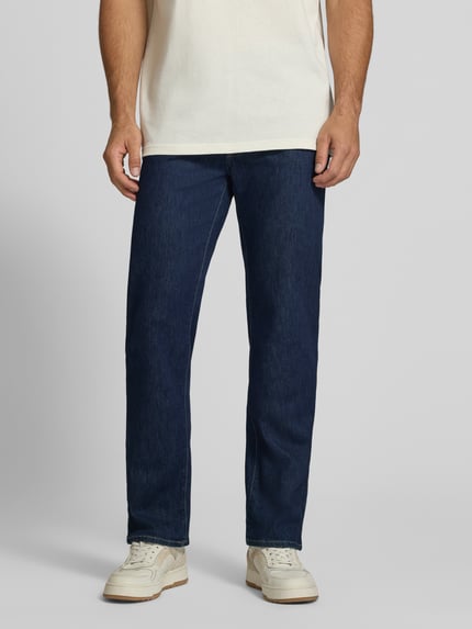 Männermodel trägt dunkelblaue Relaxed Fit Jeans aus Baumwoll-Mix Modell 'Clint' von Brax, Herren Wide & Loose Fit Jeans, Ganzkörperansicht von vorne.