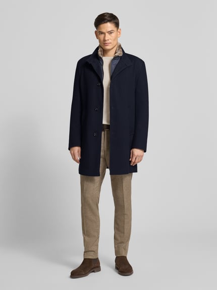 Männermodel trägt Regular Fit Mantel mit Viskose-Anteil van bugatti in donkerblauw, elastische materiaalmix, staande kraag, steekzakken, knoopsluiting. Ganzkörperansicht von vorne.