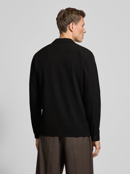 Männermodel draagt Hemdjacke mit Knopfleiste van Lindbergh in zwart, regular fit, viscosemix, borstzakken, ruglengte 71 cm, Ganzkörperansicht Rückansicht.