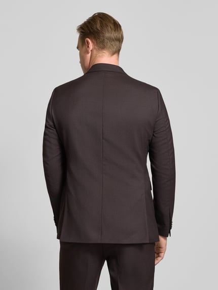 Männermodel trägt donkerbruin Slim Fit Sakko aus zuivere scheerwol Model 'Paul' van CG – CLUB of GENTS, gladde textuur, Ganzkörperansicht Rückansicht. Ruglengte bij maat 50: 74 cm, schouderbreedte: 45 cm, mouwlengte: 65 cm, reverskraag, 2-knoopsluiting, borstzak en klepzakken.