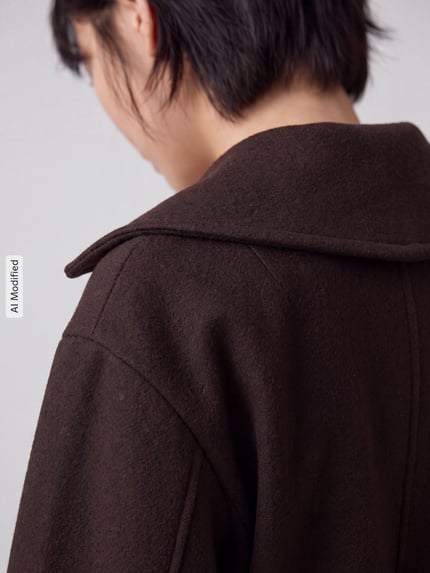 Frauenmodel trägt Regular Fit Teddy- / Webpelzjacke mit Bindegürtel Modell 'ANNE' von VERO MODA, braune Farbe, strukturierte Oberfläche, Nahaufnahme Rückansicht, KI-modifiziertes Bild.