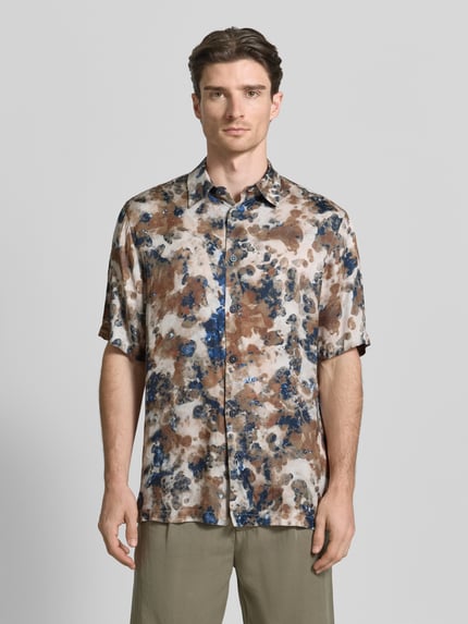 Männermodel trägt Boxy Fit Freizeithemd aus Viskose im Allover-Look von ARMANI EXCHANGE, braun-blau gemustert, Kentkragen, Knopfleiste, Ganzkörperansicht von vorne. Rückenlänge bei Größe M: 77 cm, Schulterbreite: 49 cm, Ärmellänge: 31 cm.