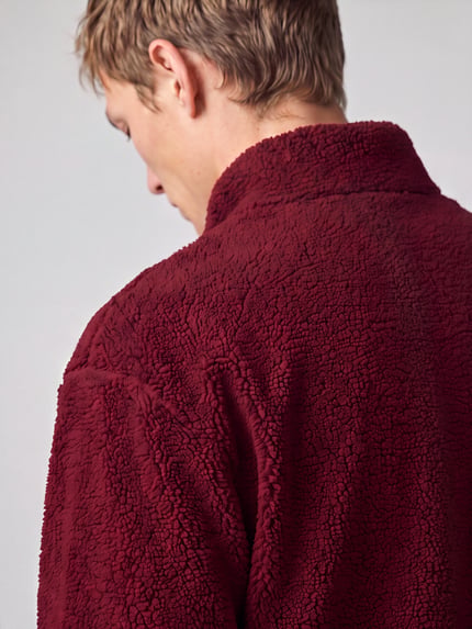 Männermodel trägt Sweatshirt mit Logo-Detail Modell 'Derylong' von HUGO in Dunkelrot, Fleece-Struktur, Nahaufnahme Rückansicht.