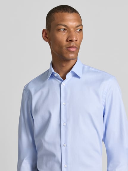 Männermodel trägt Slim Fit Business-Hemd mit Kentkragen von Jake*s aus Reine Baumwolle, extralang, hellblau, Nahaufnahme Oberkörper. Rückenlänge 83 cm, Schulterbreite 41 cm, Ärmellänge 71 cm, Knopfleiste, Sportmanschetten, abgerundeter Saum.