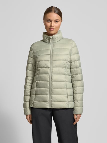 Frauenmodel trägt Steppjacke mit Stehkragen von Christian Berg Woman Selection in hellem Grün, gesteppt, Reißverschluss, Ganzkörperansicht von vorne, Regular Fit, zwei Reißverschlusstaschen, glatte Textur, mittlere Rückenlänge bei Größe 36.