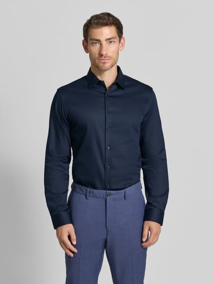Männermodel trägt Slim Fit Businesshemd aus Baumwoll-Mix Modell 'FILIP' von Selected Homme in Dunkelblau, glatte Struktur, Ganzkörperansicht von vorne. Herren Businesshemd von Selected Homme.
