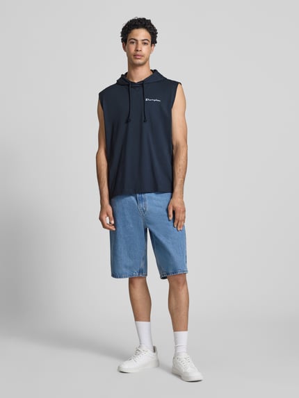 Männermodel trägt Hoodie mit Label-Stitching von CHAMPION in Dunkelblau, reine Baumwolle, Regular Fit, Ganzkörperansicht von vorne.
