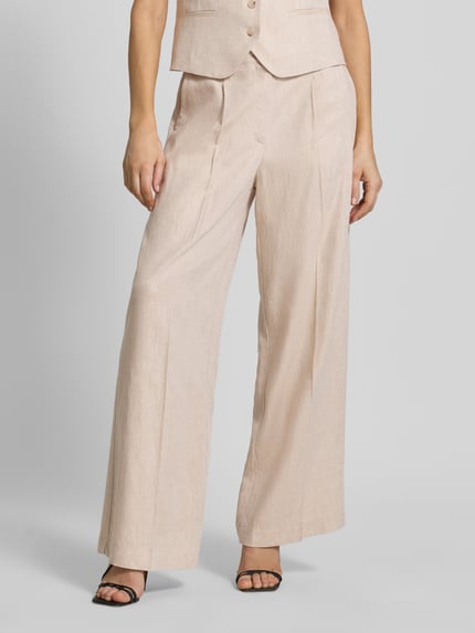 Frauenmodel trägt Wide Fit Stoffhose aus Viskose-Mix Modell 'Dazia' von B.Young, beigefarbener Leinen-Look, Bügelfalten, Nahaufnahme Unterkörper. Damen Stoffhose, Viskose-Mix mit Leinen-Anteil, Gesäßtaschen, Knopf- und Reißverschluss, Bundweite bei Größe 36: 37 cm, Innenbeinlänge 77 cm.