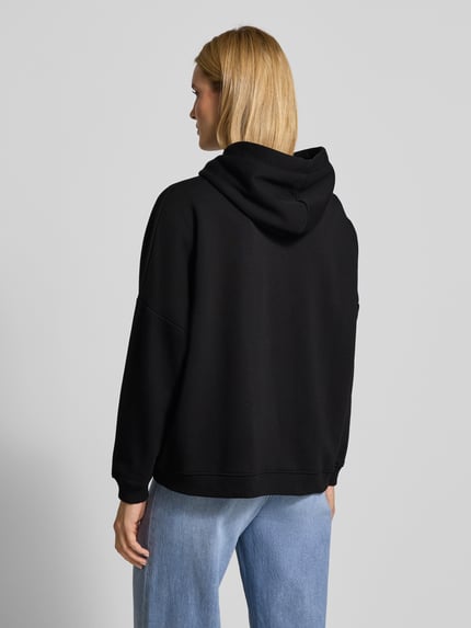 Vrouwenmodel draagt Oversized Hoodie met Kapuze van miss goodlife in zwart, pure katoen, labeldetail, geribde boorden, rugaanzicht volledig lichaam