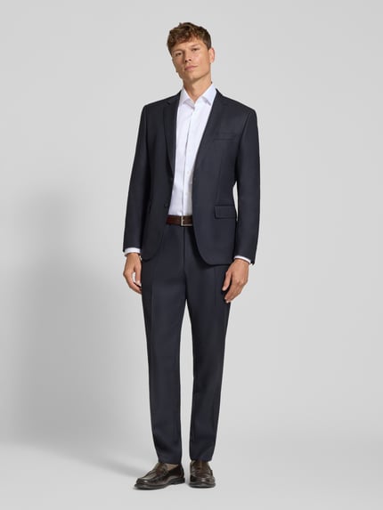 Männermodel trägt Modern Fit Businesshemd aus reiner Baumwolle Modell 'Global Kent' von OLYMP in Weiß zu Anzug, Ganzkörperansicht von vorne, Herren Businesshemd von OLYMP.